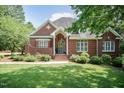 Charming brick home featuring a well-manicured lawn, beautiful landscaping, and inviting front entrance at 109 Fox Trap Ct, Garner, NC 27529