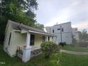 Exterior view of yellow home with porch, showcasing its architecture and landscape at 1106 Fargo St, Durham, NC 27707