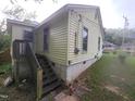 Rear exterior view with stair access, highlighting architectural details and yard space at 1106 Fargo St, Durham, NC 27707