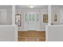 Bright foyer featuring hardwood floors, white trim, and decorative glass door with sidelights at 11100 Honeycutt Rd, Raleigh, NC 27614