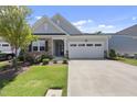 Inviting home exterior featuring a well-kept lawn, stone accents, and an attached two-car garage at 1125 Surveyor Dr, Durham, NC 27703