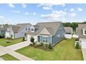 Inviting home boasts pristine lawn, attached garage, and lovely architectural details at 125 Alumroot Rd, Holly Springs, NC 27540