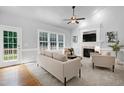 Bright living room with fireplace, ceiling fan, and access to the outdoor deck at 1276 Dalgarven Dr, Apex, NC 27502