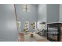 Staged living room featuring hardwood floors, a fireplace, tall ceilings, and plenty of natural light at 145 Mariah Towns Way, Garner, NC 27529