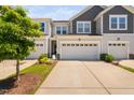 View of the townhome with a two-car garage and a well-maintained lawn at 150 Gosford Ln, Garner, NC 27529