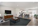 Bright living room with modern furnishings, an open floor plan, and hardwood floors at 16 Powder Ct, Angier, NC 27501