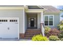 A covered front entrance with brick steps and a white railing leads to the home's front door at 16 Woodglen Dr, Clayton, NC 27527