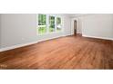 Bright living room with beautiful hardwood floors and large windows for natural light at 1708 Lake Park Dr, Raleigh, NC 27612