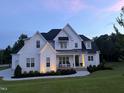Charming two-story home at dusk, highlighting the architectural details and landscape lighting at 20 Delia Ln, Pittsboro, NC 27312