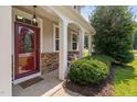 Inviting front porch with stone accents and a decorative glass front door at 200 Woodvale Way, Fuquay Varina, NC 27526