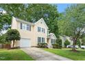 Exterior view of the home featuring an attached garage, well-maintained lawn, and traditional architecture at 205 Mint Hill Dr, Cary, NC 27519