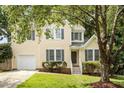 Traditional home with a well-kept lawn, an attached garage, and mature trees in the front yard at 205 Mint Hill Dr, Cary, NC 27519