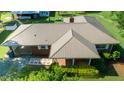 An aerial view displays a brick home with metal roof and a lovely yard at 2081 Stone Street Ext, Mebane, NC 27302