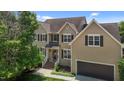 Beautiful two-story home featuring a brick foundation, lush lawn, attached garage, and a welcoming front entrance at 2104 Brockfield Ct, Raleigh, NC 27614