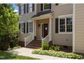 Inviting front entrance with a red door, white railings, brick steps, and tasteful landscaping at 2104 Brockfield Ct, Raleigh, NC 27614