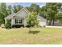 Attractive home featuring a neatly trimmed lawn, mature landscaping, and an attached garage at 220 Oxfordshire Dr, Fuquay Varina, NC 27526