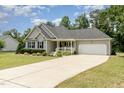 Lovely single-Gathering home featuring a well-maintained lawn, covered porch, and a two-car garage at 220 Oxfordshire Dr, Fuquay Varina, NC 27526