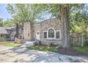 Stone exterior home featuring unique architectural details, with mature trees surrounding at 2203 University Dr, Durham, NC 27707