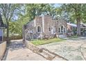Stone exterior home featuring unique architectural details, with mature trees surrounding at 2203 University Dr, Durham, NC 27707