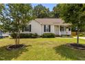 Well-maintained home with a green lawn, mature trees, and a welcoming front porch at 304 Quailwood Dr, Fuquay Varina, NC 27526