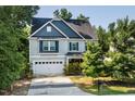Lovely two-story home featuring blue accents, a well-kept lawn, and an attached two-car garage at 3401 Grosbeak Way, Raleigh, NC 27616