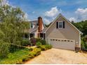 Home exterior with a two-car garage and driveway, lush greenery, and a well-maintained lawn at 3619 Nc-57, Hillsborough, NC 27278