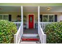 Charming covered front porch with a bright red front door and white railing at 3619 Nc-57, Hillsborough, NC 27278