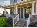 Welcoming front porch with brick stairs, white railings, decorative columns, and well-maintained landscaping at 3624 Regent Pines Dr, New Hill, NC 27562