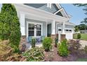 Inviting front porch enhanced by stone supports, attractive seating, and lush landscaping at 365 Middleton Pl, Chapel Hill, NC 27516
