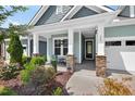 Welcoming front porch with stone columns, stylish seating, and beautiful landscaping at 365 Middleton Pl, Chapel Hill, NC 27516