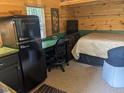 Charming cabin interior featuring a bed, a mini fridge and a work area with log walls at 4008 Old Nc 86, Hillsborough, NC 27278