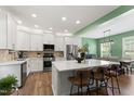 Modern kitchen with stainless steel appliances, a large island, and white cabinets and an eat-in dining area at 404 Blooming Meadows Rd, Holly Springs, NC 27540