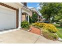Charming brick townhome with a two-car garage, walkway, and vibrant landscaping at 4060 Barton Park Pl, Raleigh, NC 27613