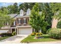 Beautiful brick townhome with a two-car garage, complemented by lush landscaping and mature trees at 4060 Barton Park Pl, Raleigh, NC 27613