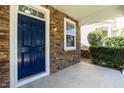 Close-up of a front porch showing the stone facade, a blue front door, and manicured shrubbery at 418 Byrams Ford Dr, Cary, NC 27513