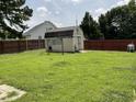 Well-maintained storage shed in a spacious, grassy backyard with fencing at 44 Glen Meadow Dr, Angier, NC 27501