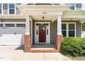 Inviting front door entrance with brick columns, white trim, and a 