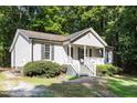 Beautiful home with a welcoming front porch and classic siding, nestled in a wooded lot at 472 Shawnee Dr, Louisburg, NC 27549