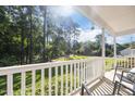 Relaxing porch area with a view of a beautiful green lawn and lush trees at 472 Shawnee Dr, Louisburg, NC 27549