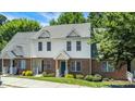 Two story townhome featuring brick and vinyl siding, well-maintained landscaping, and a green front yard at 4802 Parkville Dr, Raleigh, NC 27604