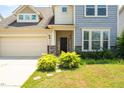 Home with two-car garage, stone accents and manicured shrubs leading to the front door at 517 Eagles Way, Mebane, NC 27302