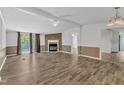 Open living room with wood floors, fireplace, ceiling fan and sliding glass doors to a balcony at 64 Doughty Ln # E, Middlesex, NC 27557