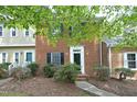 Charming brick townhome with a well-maintained lawn and garden at the front of the house at 747 Weathergreen Dr, Raleigh, NC 27615