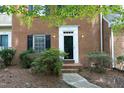 Inviting brick townhome with a black front door, flanked by lovely shrubs and a stone walkway at 747 Weathergreen Dr, Raleigh, NC 27615
