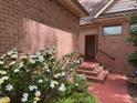 Brick walkway leading to front door, lined with blooming white flowers and lush greenery at 81106 Alexander, Chapel Hill, NC 27517