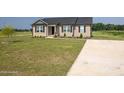 Home with driveway and manicured front yard and garden at 82 Mamie Rd, Benson, NC 27504