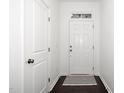Bright hallway with dark floors, white door, striped rug and transom window at 835 New Derby Ln, Apex, NC 27523