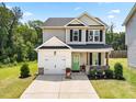 Inviting two-story home featuring a lush green lawn, a one-car garage, and a lovely green front door at 84 Elliot Dr Dr, Clayton, NC 27520