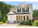 Attractive two-story home with an attached garage, a charming green door, and lovely landscaping at 84 Elliot Dr Dr, Clayton, NC 27520