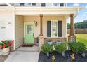 Welcoming front porch with charming wooden columns, a vibrant green door, and stylish landscaping at 84 Elliot Dr Dr, Clayton, NC 27520